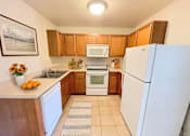 Thumbnail 2 of 30 - A kitchen with a white fridge, white dishwasher, and white sink.