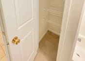 Thumbnail 6 of 30 - A white door with a gold handle is open to a white pantry with empty shelves.