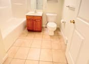 Thumbnail 5 of 30 - A white bathroom with a toilet, sink, and bathtub.