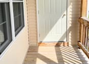 Thumbnail 17 of 30 - A white door is on the left side of a porch.