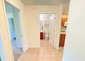 Thumbnail 4 of 30 - A hallway with tiled floors and white walls.
