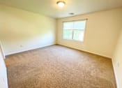 Thumbnail 11 of 30 - A room with a carpeted floor and a window.