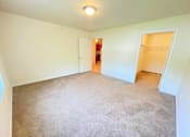 Thumbnail 14 of 30 - A room with a carpeted floor and two open doors.