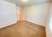 Thumbnail 13 of 30 - A room with a carpeted floor and a doorway leading to another room.