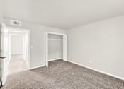 Thumbnail 24 of 31 - A room with a carpeted floor and two open doors.