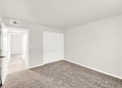 Thumbnail 25 of 31 - A large, empty room with a carpeted floor and white walls.