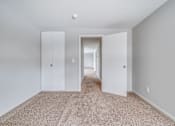 Thumbnail 20 of 38 - A hallway with carpeted flooring and white walls.