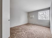 Thumbnail 21 of 38 - A room with a carpeted floor and a window.