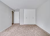 Thumbnail 22 of 38 - A room with a carpeted floor and two white doors.