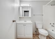 Thumbnail 15 of 38 - A white bathroom with a toilet, sink, and bathtub.