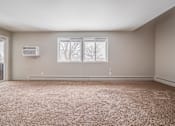 Thumbnail 18 of 38 - A room with a carpeted floor and a window showing a snowy landscape outside.