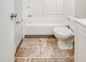 Thumbnail 14 of 17 - A white bathroom with a toilet, tub, and sink.