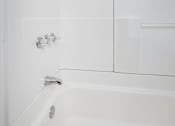 Thumbnail 12 of 17 - A white bathroom with a tub and shower.