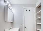 Thumbnail 13 of 17 - A white bathroom with a toilet, sink, and mirror.