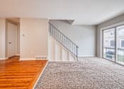 Thumbnail 9 of 17 - A room with a staircase and a sliding glass door.