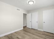 Thumbnail 16 of 26 - Three white doors in a room with wood flooring and white walls.