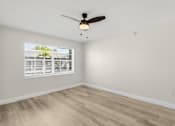 Thumbnail 15 of 26 - A room with a ceiling fan and a window with blinds.