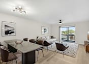 Thumbnail 2 of 26 - A modern dining room with a glass table and chairs.