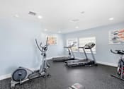 Thumbnail 18 of 26 - A room with a treadmill, elliptical trainer and a stationary bike.