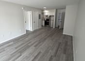 Thumbnail 10 of 23 - A room with a wooden floor and white walls.