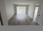 Thumbnail 9 of 23 - A room with a window and a wooden floor.