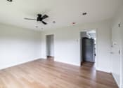 Thumbnail 2 of 49 - A room with a ceiling fan and wooden flooring.