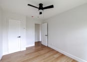 Thumbnail 4 of 49 - A room with a ceiling fan and wooden floors.