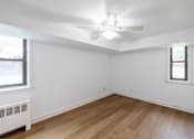 Thumbnail 6 of 49 - A room with a ceiling fan and wooden flooring.
