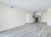 Thumbnail 3 of 23 - A spacious room with a kitchen area in the background.