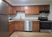 Thumbnail 8 of 38 - A kitchen with wooden cabinets and stainless steel appliances.