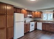 Thumbnail 2 of 26 - A kitchen with wooden cabinets and white appliances.