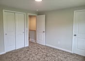 Thumbnail 5 of 26 - A room with white doors and carpeted floor.