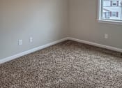 Thumbnail 7 of 26 - A room with a carpeted floor and a window.