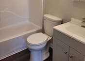 Thumbnail 14 of 26 - A white toilet sits next to a white sink in a bathroom.