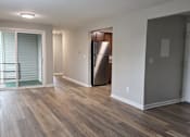 Thumbnail 37 of 38 - A room with wooden flooring and a refrigerator in the corner.