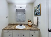 Thumbnail 5 of 18 - A bathroom with a sink, mirror, and cabinets.