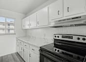 Thumbnail 22 of 41 - A kitchen with white cabinets and a black stove top oven.