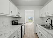 Thumbnail 19 of 41 - A kitchen with white cabinets and marble countertops.