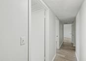 Thumbnail 38 of 41 - A long hallway with a light switch on the wall.