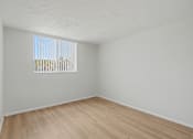 Thumbnail 16 of 41 - Empty room with wooden floor and a window.