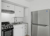 Thumbnail 2 of 41 - A modern kitchen with a stainless steel refrigerator and black stove.