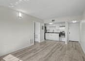 Thumbnail 9 of 26 - A kitchen with white cabinets and a wooden floor.