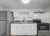 Thumbnail 8 of 26 - A kitchen with white cabinets and a black oven.
