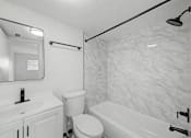 Thumbnail 15 of 26 - A white bathroom with a toilet, sink, and bathtub.