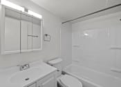 Thumbnail 14 of 29 - A white bathroom with a toilet, sink, and bathtub.