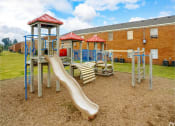 Thumbnail 12 of 17 - a playground with a slide and chairs in front of a building