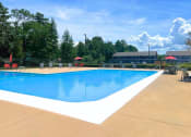 Thumbnail 13 of 17 - a swimming pool with chairs around it and trees in the background