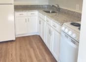 Thumbnail 1 of 13 - a kitchen with white cabinets and a stove and a sink