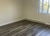 Thumbnail 7 of 13 - an empty living room with wooden floors and a window