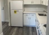 Thumbnail 9 of 13 - a kitchen with white cabinets and a refrigerator